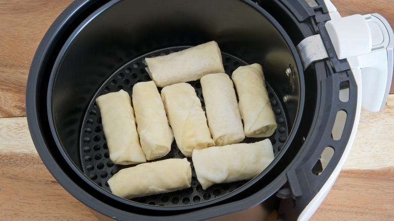 Frozen spring rolls in an air fryer basket