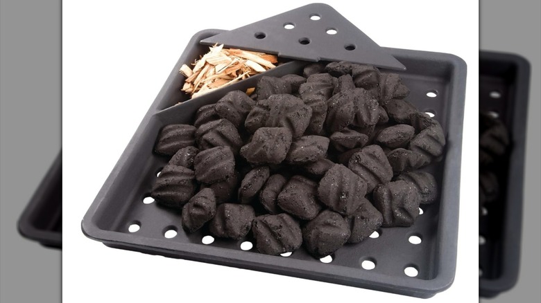 A cast iron tray full of charcoal and wood chips.