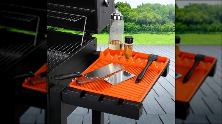 A silicone tool mat on a gas grill's side table.