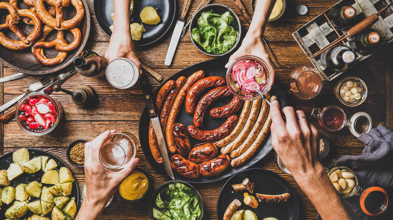 Table with sausages, pretzels, beer, and vegetables