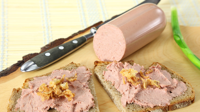 Liver sausage and bread on wooden cutting board