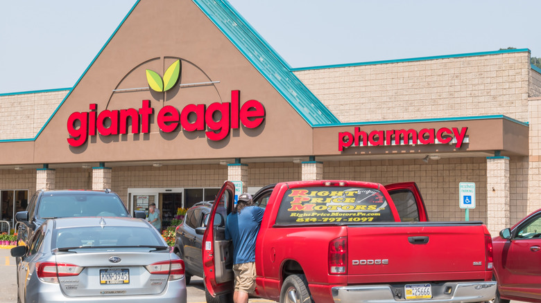 The exterior of Giant Eagle with a man putting things in his red pick up truck in front of the store