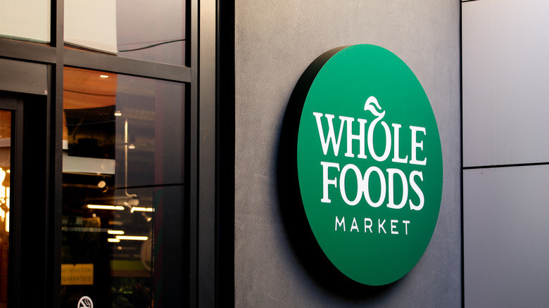 The exterior of Whole Foods with a sign by the door