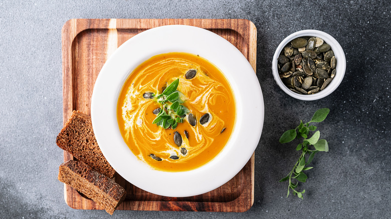 A creamy pumpkin soup topped with fresh oregano.