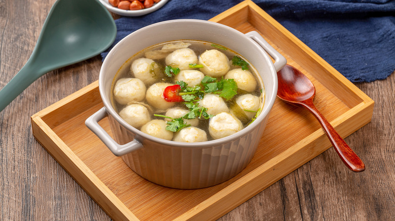 A small pot of fishball soup with red chiles and fresh cilantro.