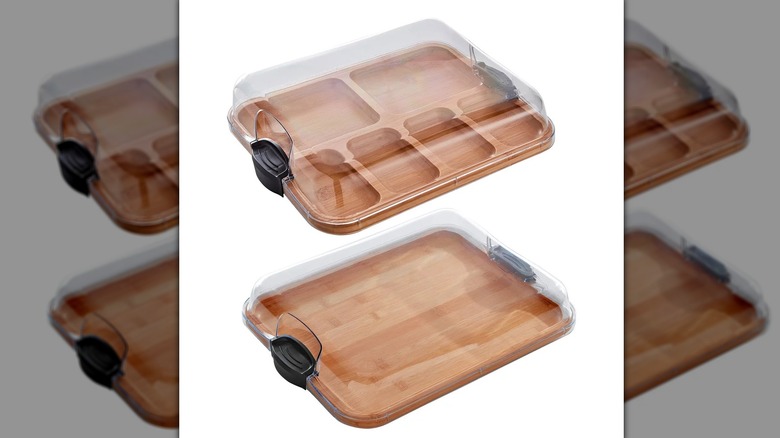 Two wooden cutting boards are covered by clear plastic covers