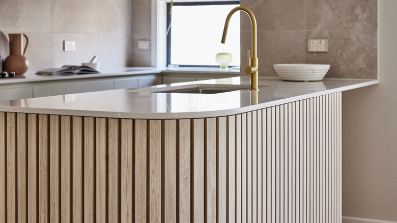 Kitchen island with a fluted wood base