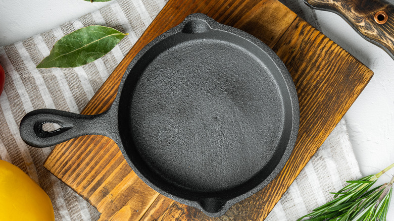 A cast-iron skillet sits on a wooden cutting board