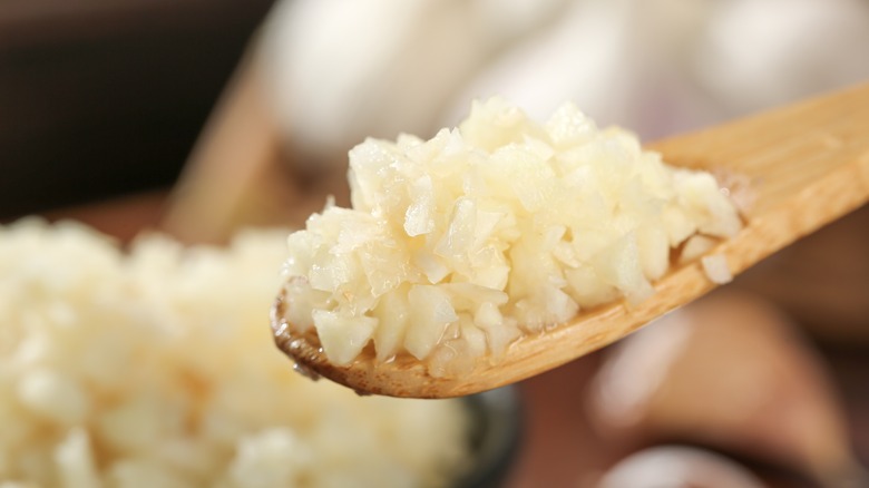 Wooden spoon of finely minced garlic