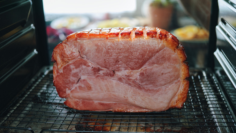 Baked ham on pan with wire rack inside oven