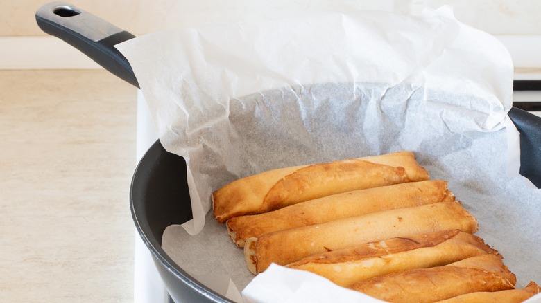 parchment paper-line frying pan full of rolled pancakes