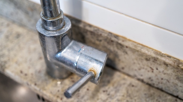 Bottom of kitchen sink faucet covered in hard water stains