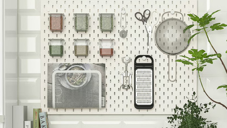 A white pegboard with shelves in a clean kitchen.