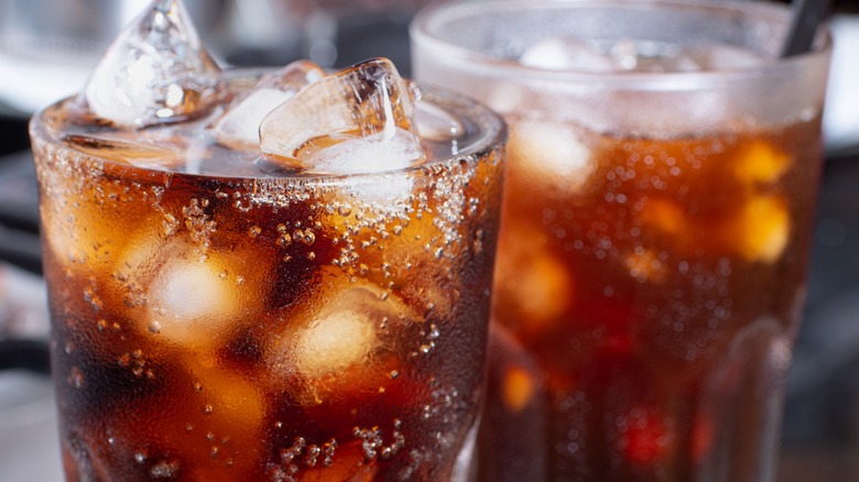 Two glasses of brown soda with ice