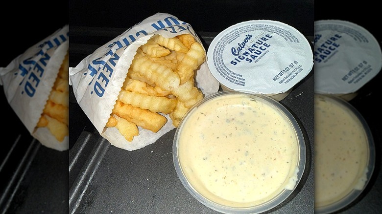 An order of fries sits next to two containers of Culver's Signature Sauce.