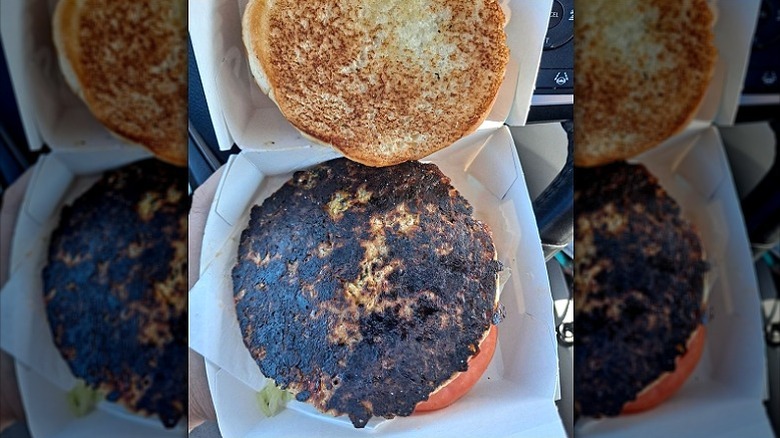 A burnt veggie burger at Culver's sits in a cardboard box.
