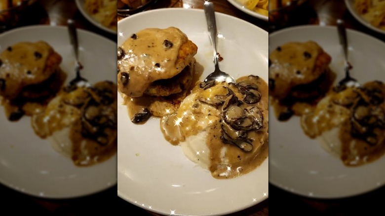 A plate of stuffed chicken marsala with mashed potatoes