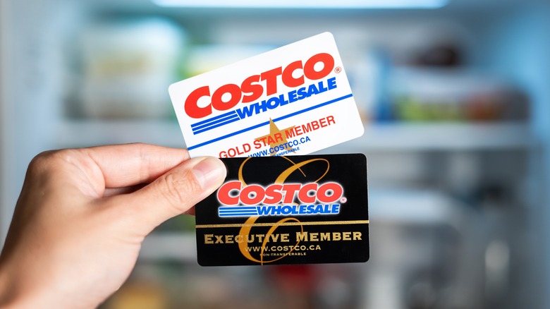 Hand holding Costco Gold Star and Executive membership cards