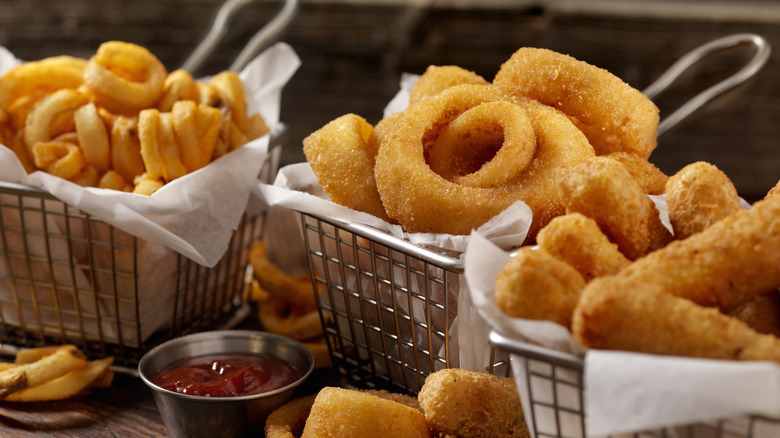 Metal baskets full of fries, onion rings, and mozzarella sticks