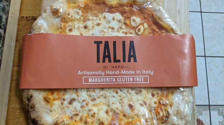 A Talia di Napoli frozen pizza sits on a wooden counter
