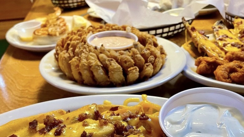 Table loaded with Texas Roadhouse appetizers like the Cactus Blossom and tater skins