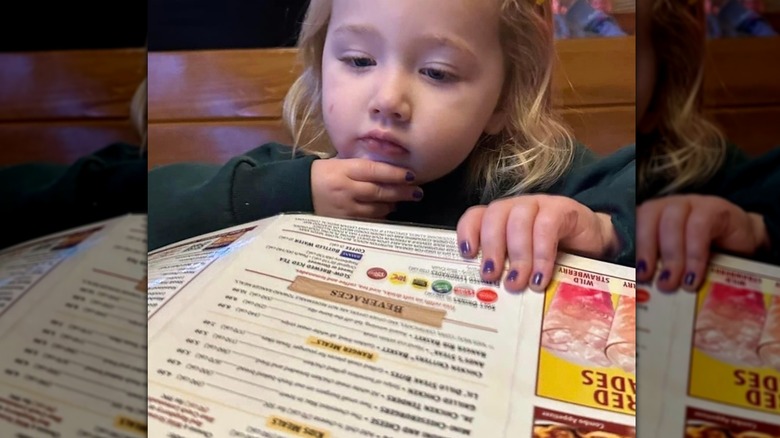 Child looking over a Texas Roadhouse menu