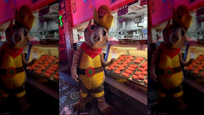 Texas Roadhouse armadillo mascot in front of display case of steaks