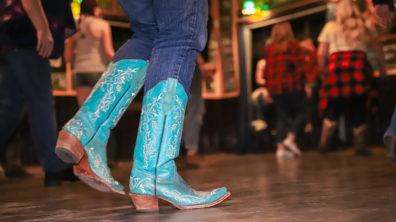a line dancer's feet wearing turquoise cowboy boots