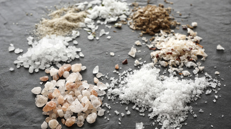 piles of salts in different colours and textures on slate background