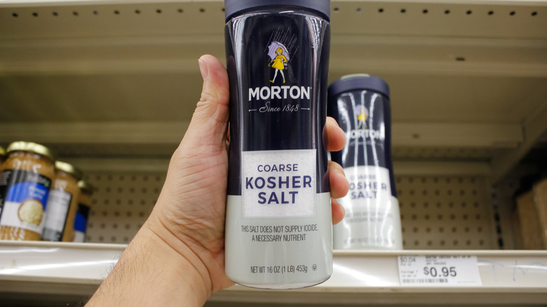 hand holding a container of Morton coarse kosher salt