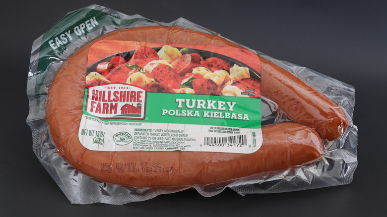 A sealed package of Hillshire Farm Turkey Polska Kielbasa is on a black background.