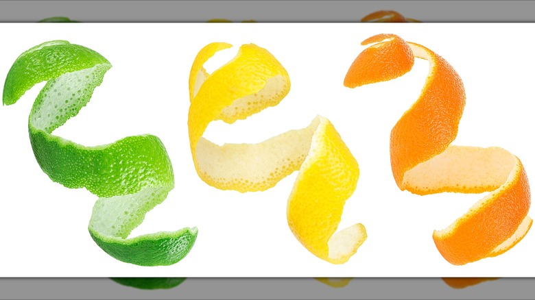 Spirals of lime, lemon, and orange rind on a blank background