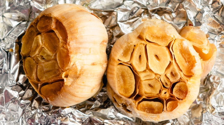 Piece of aluminum foil with heads of roasted garlic