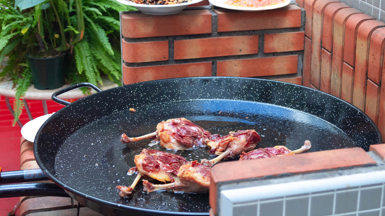 Frying duck on a paella pan
