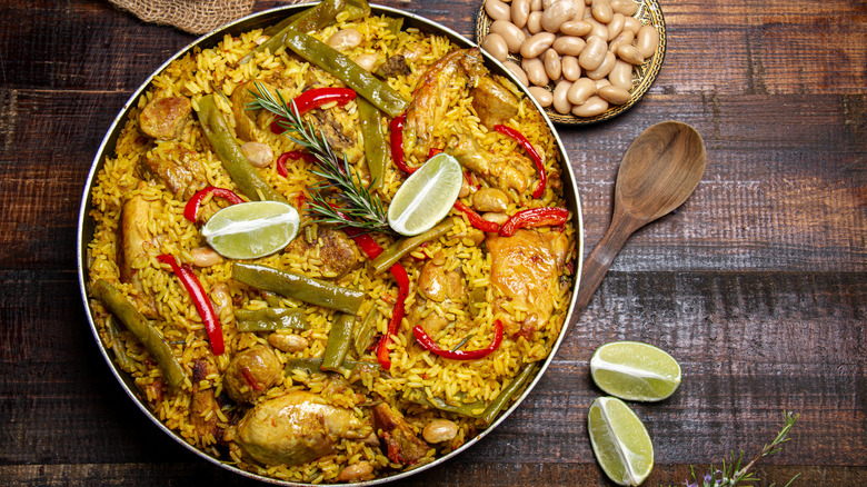 Paella with chicken, green beans and a sprig of rosemary on top
