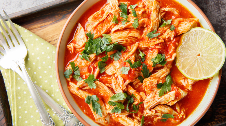 Boneless chicken pieces in tomato broth with chopped herbs