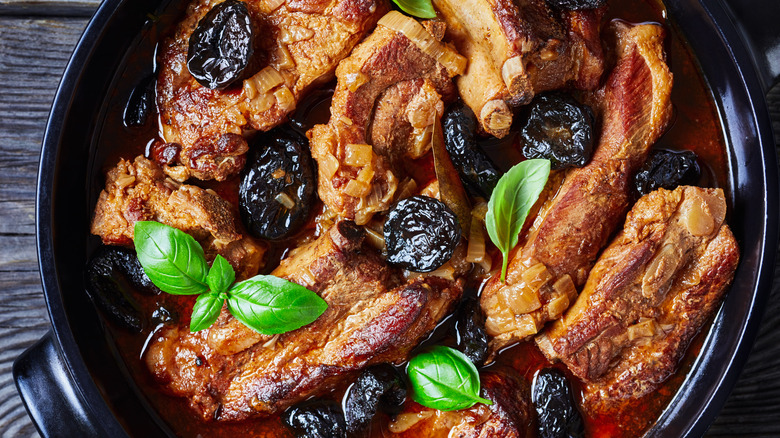 Pork short ribs with plums and sprigs of basil
