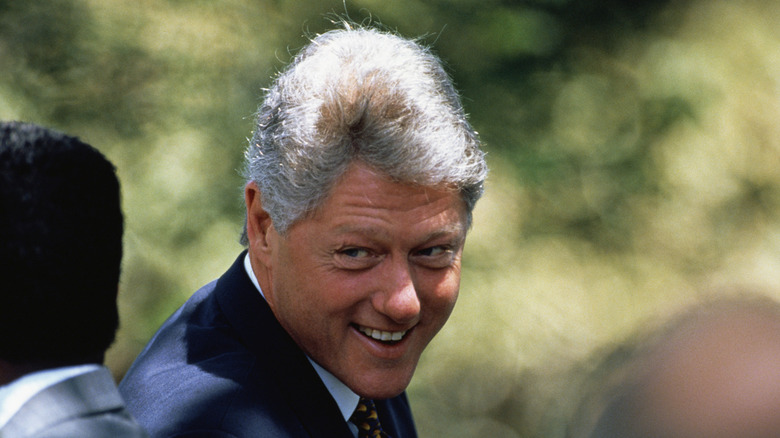 President Clinton seen smiling among a group of people