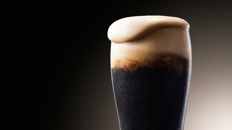 Overflowing glass of stout beer
