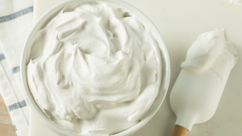 Stabalized whipped cream in a bowl and on a spatula