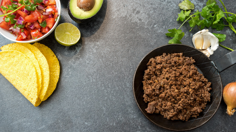Taco meat with tomato salsa, lemon avocado and tortillas