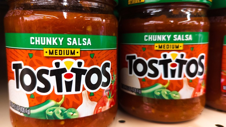 Two jars of tostitos salsa on a shelf in a store