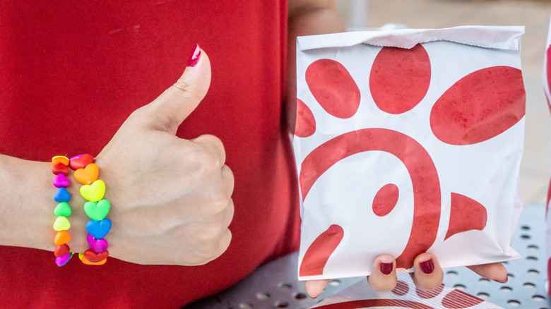 Person gives a thumbs up holding a Chick-fil-A order