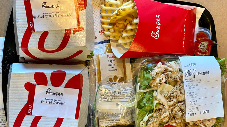 Receipt affixed to a Chick-fil-A order with sandwiches and a salad