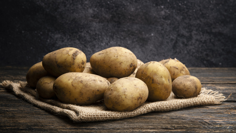 pile of raw potatoes on burlap sack