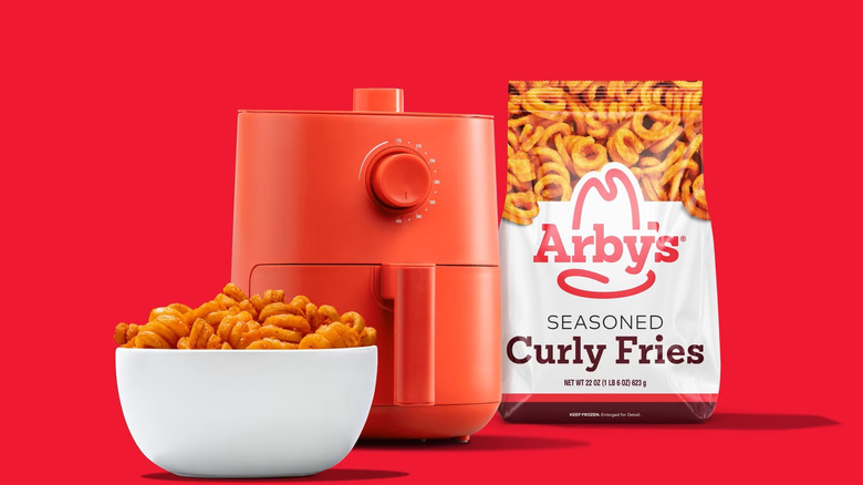 Arby's Seasoned Fries in a bowl beside an airfryer and a bag of Arby's fries.