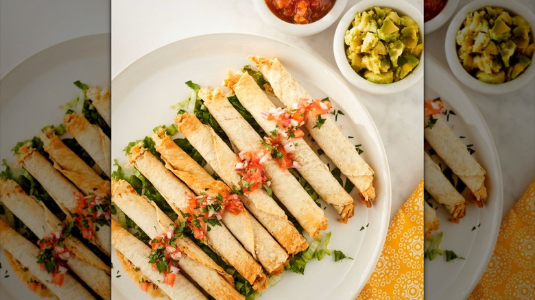 A plate of chicken taquitos with salsa.