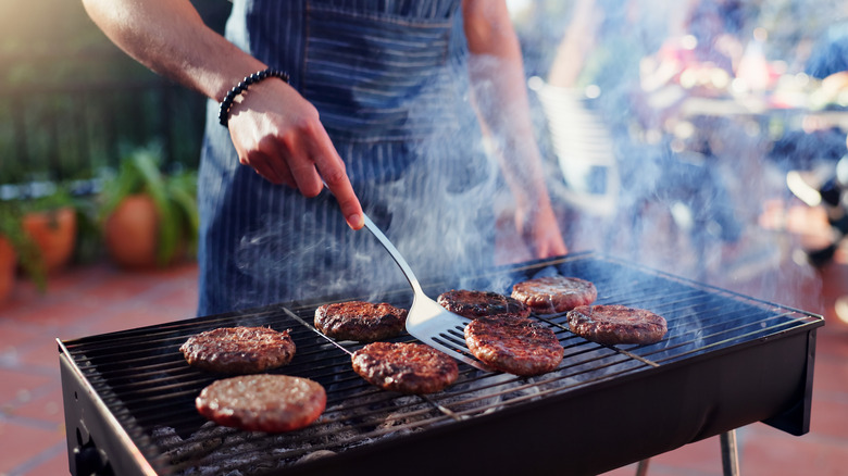 Person grilling burger patties