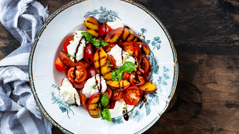 Bowl with grilled peaches, tomatoes, mascarpone cheese, and balsamic vinegar