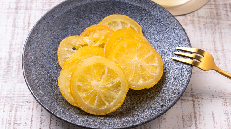 Fried lemon slices on a blue plate with a gold fork